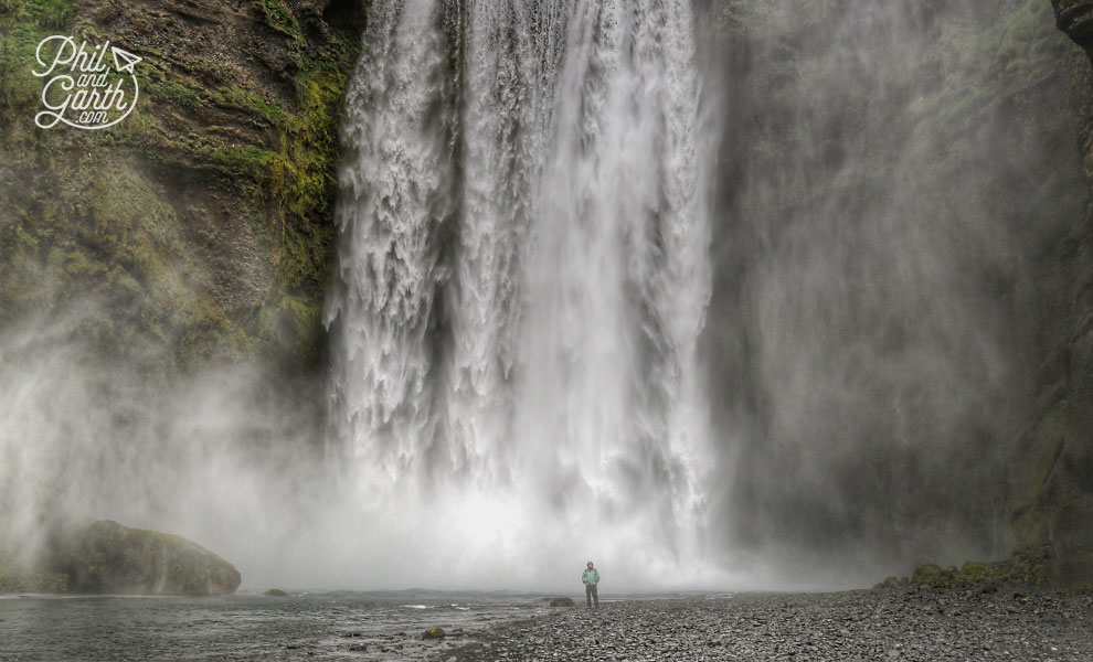 Iceland-south-Garth-standing-at-the-bottom-of-Skogafoss-waterfall