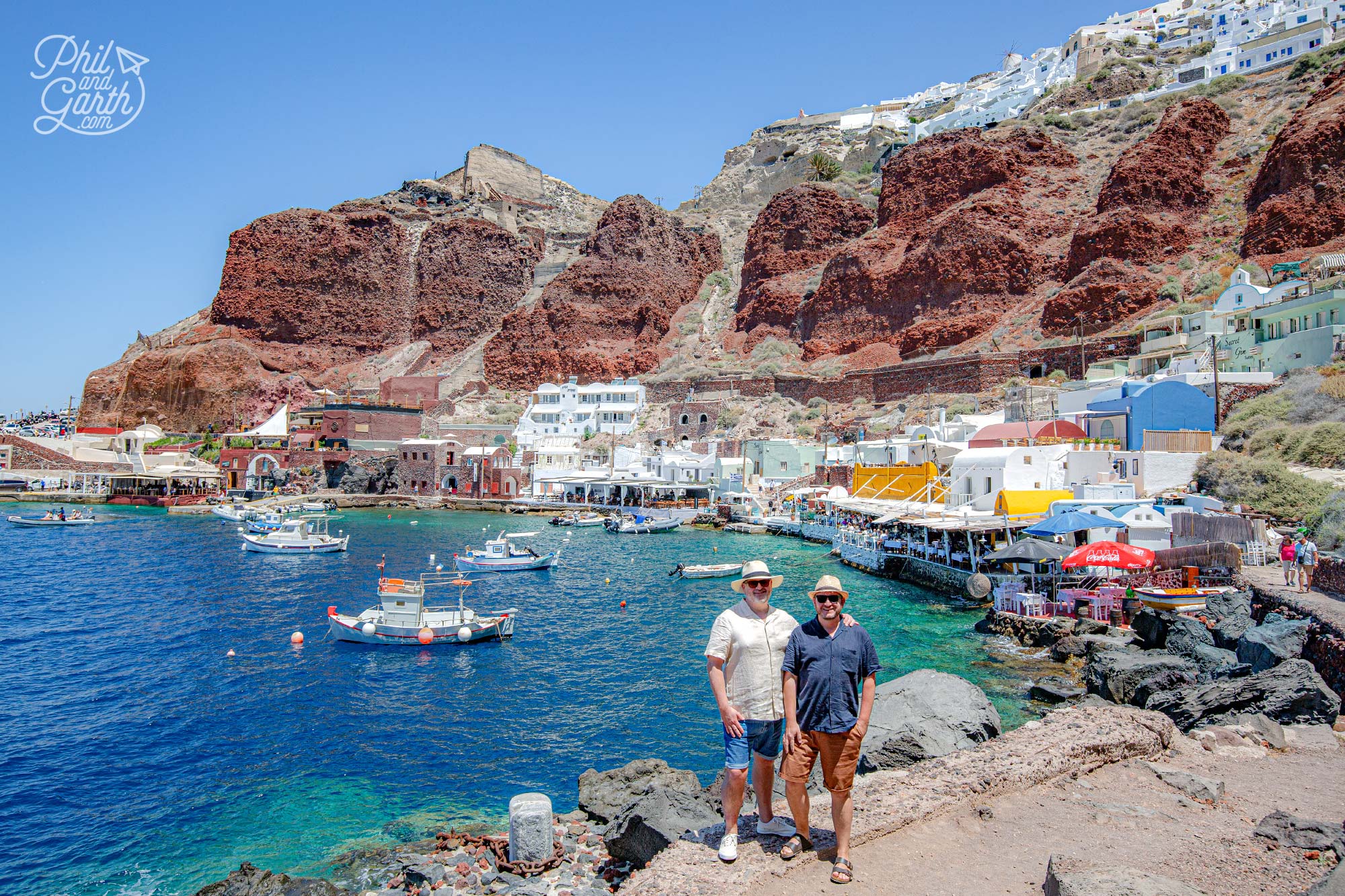 Santorini Instagram Spots: Ammoudi Bay's cliffs and boats bask in the warm sunshine