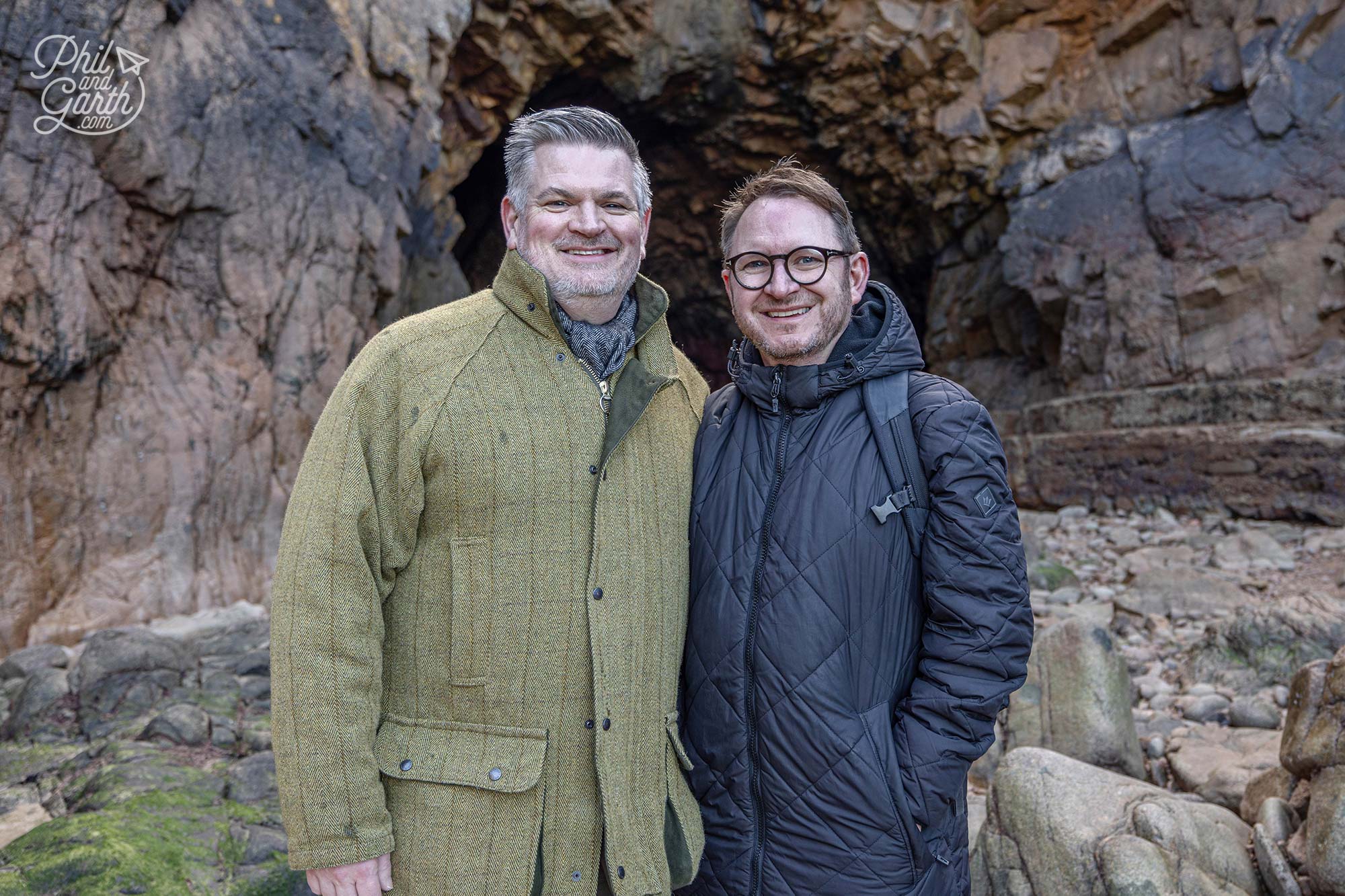 Phill and Garth next to Plémont Bay’s hidden caves revealed at low tide